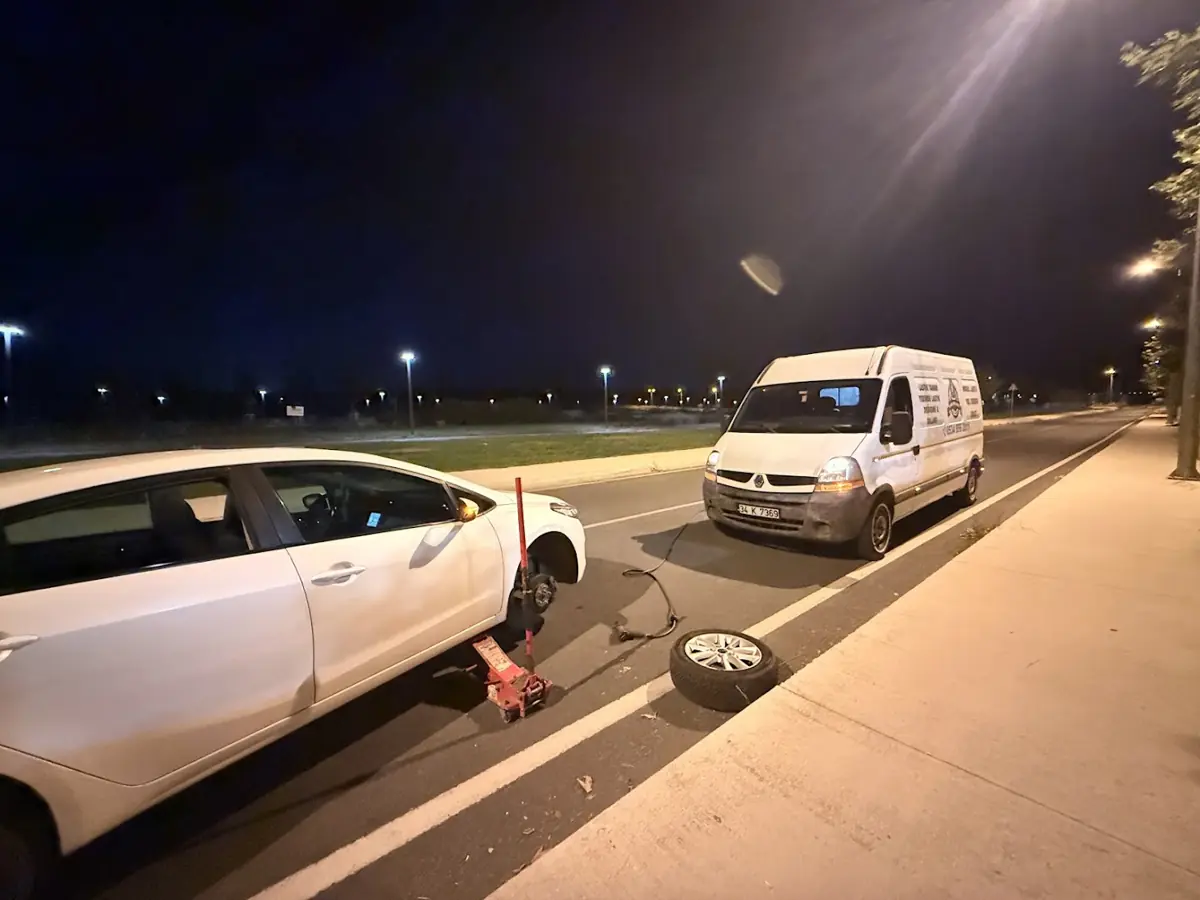 Gece yol kenarında sökülmüş lastik ve servis aracı