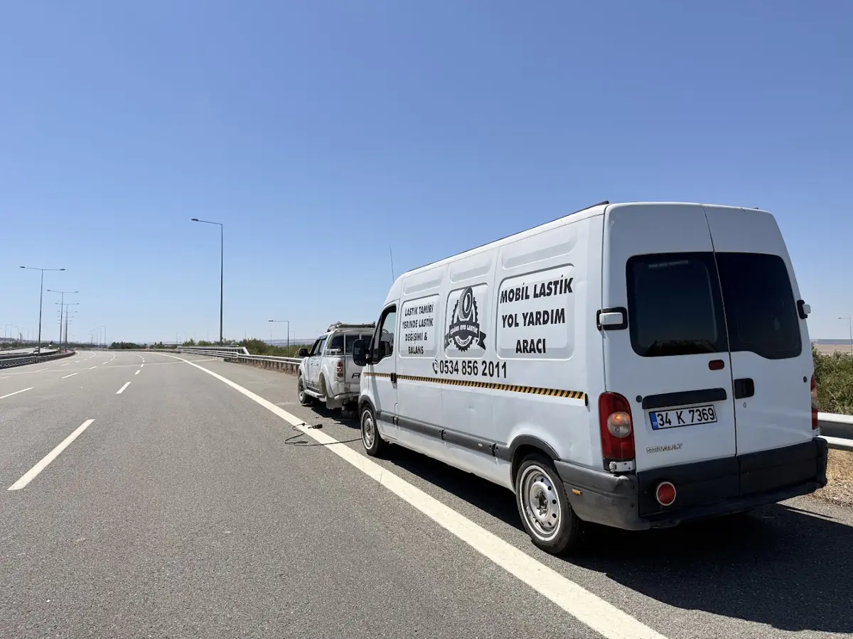 Otoyolun emniyet şeridinde duran mobil lastik yol yardım aracı ve arızalı otomobil