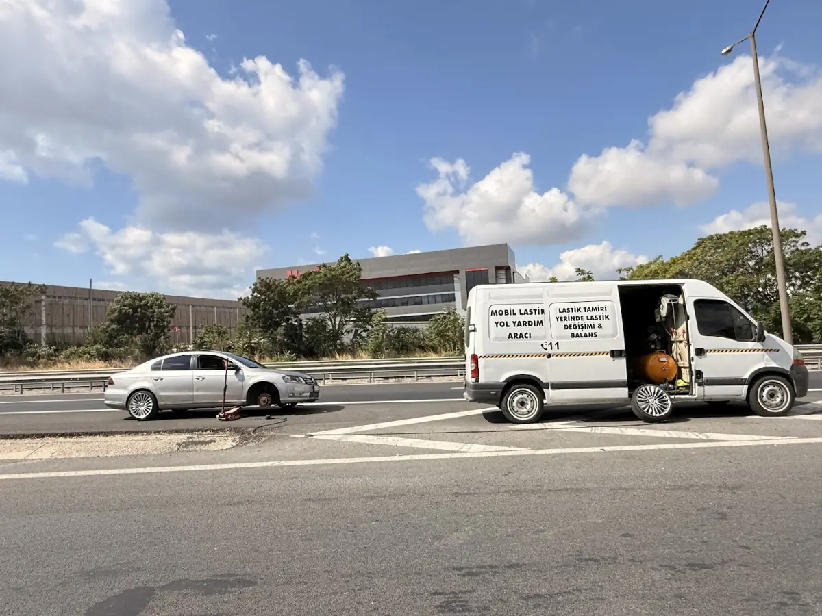 Otoyol kenarında lastiği değiştirilen otomobil ve servis aracı